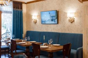 jadalnia z dwoma stołami i niebieską kanapą w obiekcie GANZ HOTEL w Iwano-Frankiwsku