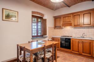 una cucina con armadi in legno e tavolo in legno di Agriturismo Fadanelli - La Cantina a Lamporecchio