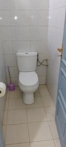 ein Bad mit einem weißen WC in einem Zimmer in der Unterkunft ADOUFE in Cotonou