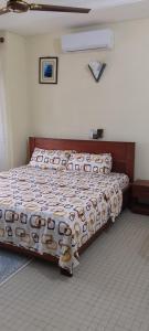 ein Schlafzimmer mit einem Bett mit einer Bettdecke darauf in der Unterkunft ADOUFE in Cotonou