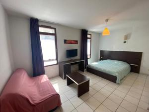 a bedroom with a bed and a chair at Studio Cité médiévale 250 m in Carcassonne