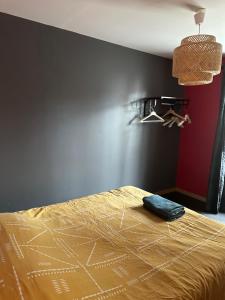 a bedroom with a bed and a red wall at Appartement centre Granville in Granville