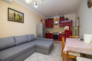 a living room with a couch and a kitchen at Sandra A2+1*** in Veli Lošinj