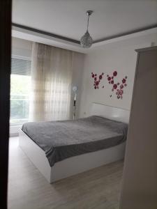 een slaapkamer met een bed met bloemen aan de muur bij Marina 1 in Antalya