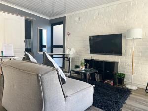 a living room with a couch and a flat screen tv at The Charming Place in Cape Town