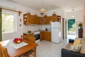 cocina y sala de estar con mesa y nevera en Villa Levante, en Vasilikos