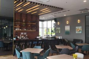 un ristorante con tavoli e sedie e un bar di Bell Suite a Sepang