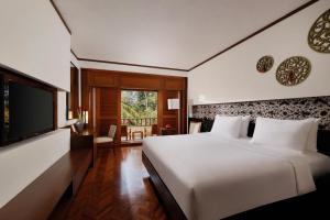 a bedroom with a large bed and a television at Nusa Dua Beach Hotel & Spa, Bali in Nusa Dua