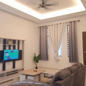 sala de estar con sofá y TV en Homestay Al Qamar Kempadang, en Kuantan