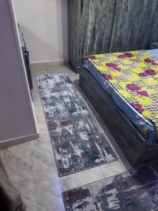 a bedroom with a bed and two rugs on the floor at Hurghada City Apartment2 in Hurghada