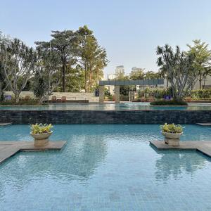 a swimming pool with two potted plants in the water at Senayan Jakarta Oasis - Gym, Pool, Netflix in Jakarta