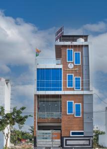 a tall building with blue windows on it at Madhav Residency in Mathura