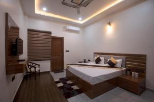 a bedroom with a bed and a television in it at Madhav Residency in Mathura