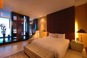 a large bedroom with a large bed and a chair at Dubai Motel in Yilan City