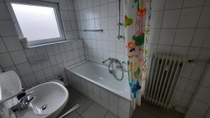 a bathroom with a sink and a tub and a window at Black Stone Apartments - Lörrach in Lörrach +29 photos