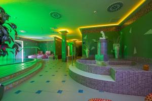 a hotel with a swimming pool with a green ceiling at Hotel Bystrina in Demanovska Dolina