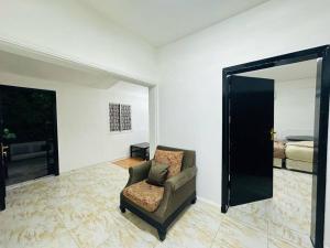 a living room with a chair and a bedroom at Private Entrance 2 Bedroom Apartment fully furnished in Abu Dhabi
