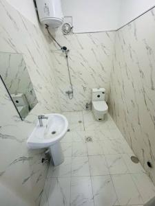 a white bathroom with a sink and a toilet at Private Entrance 2 Bedroom Apartment fully furnished in Abu Dhabi