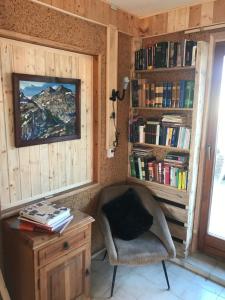 een kamer met een stoel en een bureau met boeken bij Kőlépcsős Vendégház in Nyúl