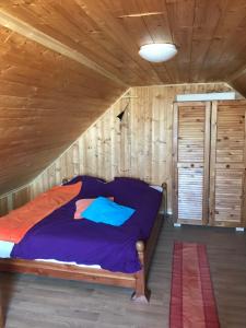 um quarto com uma cama num chalé de madeira em Kőlépcsős Vendégház em Nyúl