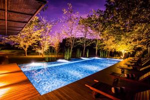 a swimming pool in a backyard at night at Kalundewa Retreat in Dambulla