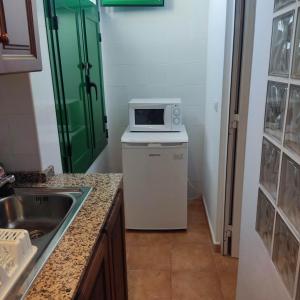 a kitchen with a microwave on top of a dishwasher at Hostal Albergue Garafía El Tablado in Tablado de la Montañeta