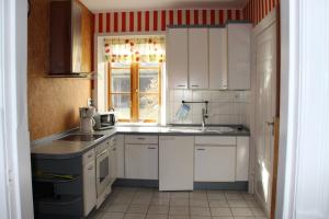 a kitchen with white cabinets and a sink and a window at Ferienwohnung Klint 2 in Dellstedt