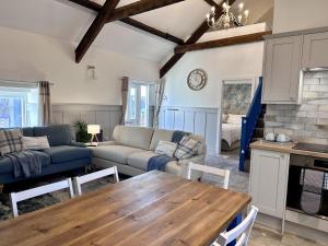 a living room with a couch and a table at The Cow Shed at Pencraig in Holyhead