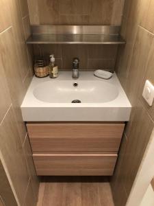 baño con lavabo blanco y suelo de madera en 47m2 Calme au cœur de Parîs, en París