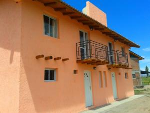 un edificio naranja con puerta y balcón en Cabañas Diaz Felices en San Rafael