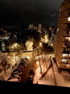 a parking lot with cars parked in the snow at night at Apartament Widokowo in Sopot
