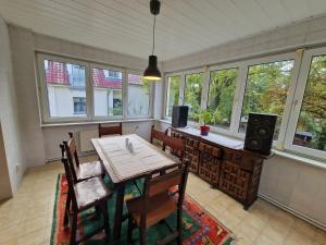 a dining room with a table and chairs and windows at Geräumige und zentrale Ferienwohnung in Stahnsdorf