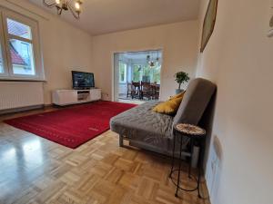 sala de estar con sofá y alfombra roja en Geräumige und zentrale Ferienwohnung en Stahnsdorf