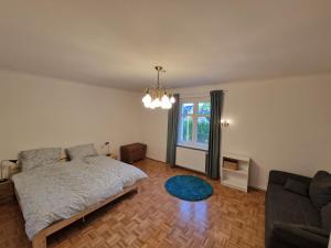 1 dormitorio con cama, sofá y ventana en Geräumige und zentrale Ferienwohnung en Stahnsdorf