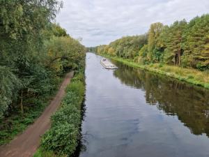 un barco en un río junto a una carretera en Geräumige und zentrale Ferienwohnung en Stahnsdorf