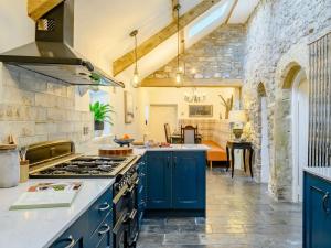a kitchen with blue cabinets and a stove at 8 bed in Southerndown 86493 in Southerndown