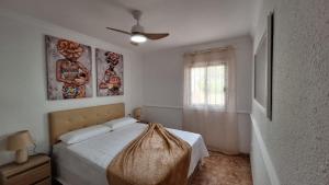 a white bedroom with a bed and a window at FRANCY PLACE in Costa Del Silencio