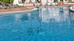 een groot zwembad met blauw water in een gebouw bij FRANCY PLACE in Costa Del Silencio