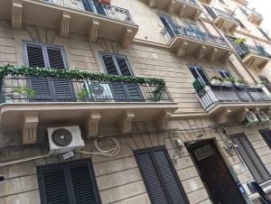 un edificio con ventanas y balcones con ventilador en Vida Rooms Luxury, en Palermo