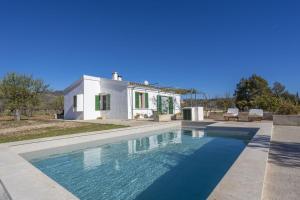 a villa with a swimming pool in front of a house at Finca Faustina Only Adults in Selva in El Port de la Selva