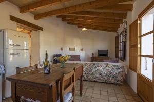 a kitchen with a table and a couch and a bottle of wine at Finca Faustina Only Adults in Selva in El Port de la Selva