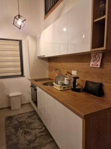 Una cocina con gabinetes blancos y un fregadero. en Apartman BJELA, en Bjelašnica