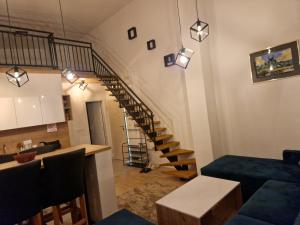 a living room with a staircase and a blue couch at Apartman BJELA in Bjelašnica