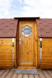 uma porta de madeira com uma janela num deque de madeira em Expérience insolite : tonneau merveilleux em Cormoyeux