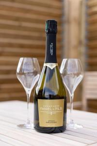 uma garrafa de vinho numa mesa com dois copos de vinho em Expérience insolite : tonneau merveilleux em Cormoyeux
