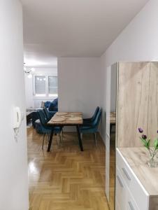 eine Küche und ein Wohnzimmer mit einem Tisch und Stühlen in der Unterkunft Apartman Ristic in Požarevac