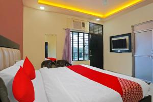 - une chambre avec un lit rouge et blanc et une télévision dans l'établissement OYO Flagship Hotel Abhinandan, à Kanpur