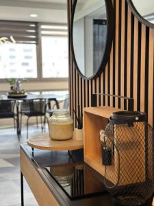 einen Spiegel und einen Tisch mit einem Glas drauf in der Unterkunft Appartement design d’architecte in Massy