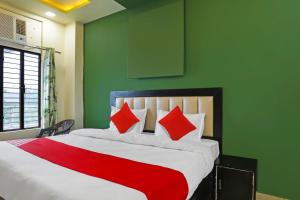 - une chambre avec un grand lit et des oreillers rouges dans l'établissement OYO Flagship Hotel Abhinandan, à Kanpur