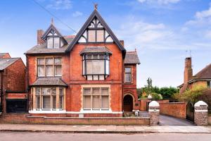 a red brick house with a black roof at Wonderful Stay 2 Bedrooms Flat in Leicester